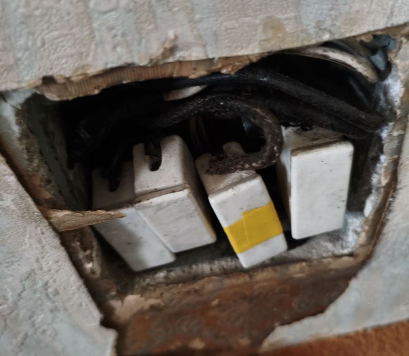 Caja de protecciones antigua con cables cubiertos en tela